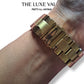 Gold watch on a wrist with 'The Luxe Vault' branding.
